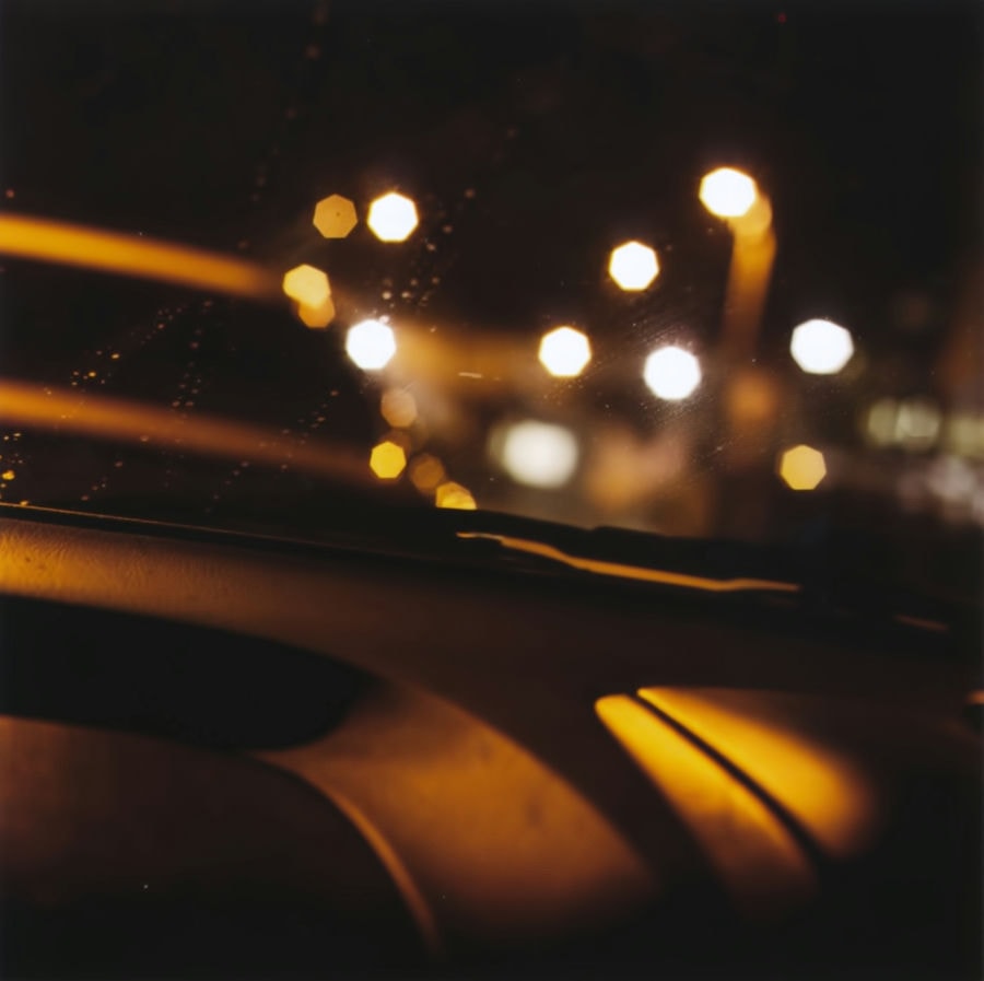 a photograph of out of focus lights, taken inside a car.